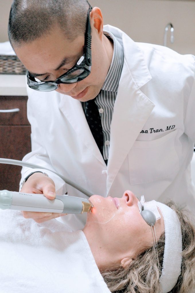 doctor performing laser skin treatment on a patient