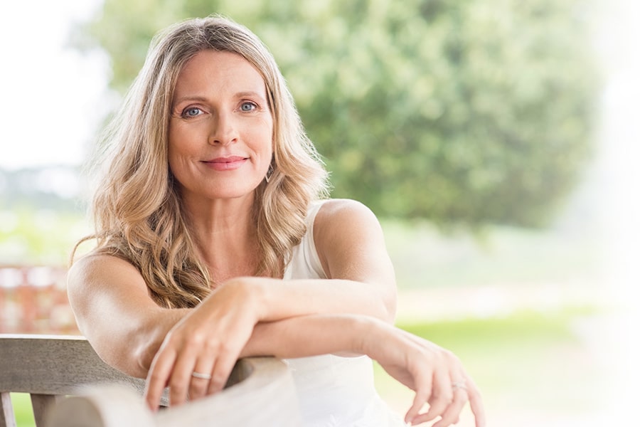 woman with clear skin, smiling and looking forward